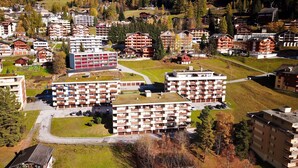 Un ensemble d’immeubles à plusieurs étages dotés de balcons, niché au cœur d’un paysage montagneux.