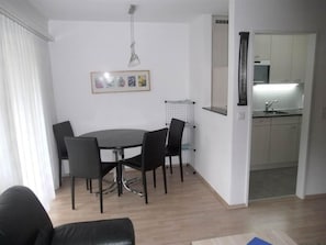Ein Essbereich mit einem runden Tisch, vier Stühlen und einer Pendelleuchte.