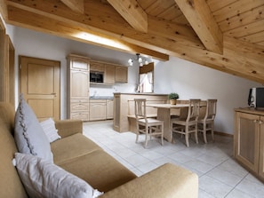 A cozy interior with a sofa, dining table, chairs, wooden cabinets, and a kitchen area. - Residenz Château # 3-bed apartment, Bad, WC by Interhome (Leukerbad)