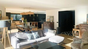 A modern living room with a sofa, coffee table, and dining area. - Villa with pool near Bassin d'Arcachon (La Teste de Buch)