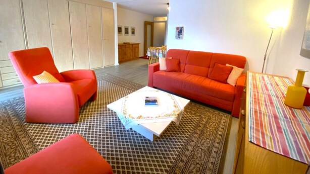 Ein Wohnzimmer mit einer Couch, einem Sessel und einem Couchtisch.