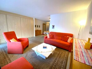 Ein Wohnzimmer mit einer Couch, einem Sessel und einem Couchtisch.