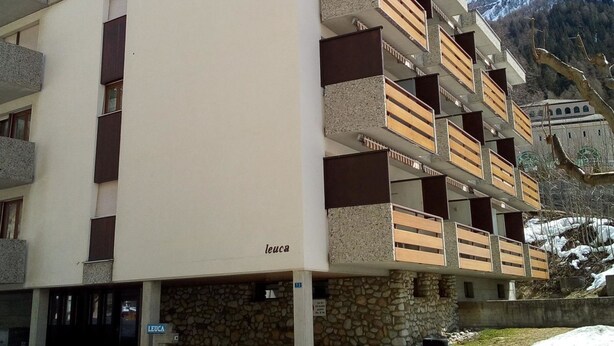 A multi-story building with balconies, a stone base, and a sign reading 'leuca'. - Leuca 24 # 2-bed apartment, Dusche, WC 2-Bettwohnung, Dusche, WC by Interhome (Leukerbad)
