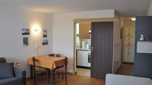 A compact living space with a dining area, kitchenette, and a separate sleeping area. - Leuca 24 # 2-bed apartment, Dusche, WC 2-Bettwohnung, Dusche, WC by Interhome (Leukerbad)