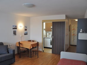 A compact living space with a dining area, kitchenette, and a separate sleeping area. - Leuca 24 # 2-bed apartment, Dusche, WC 2-Bettwohnung, Dusche, WC by Interhome (Leukerbad)