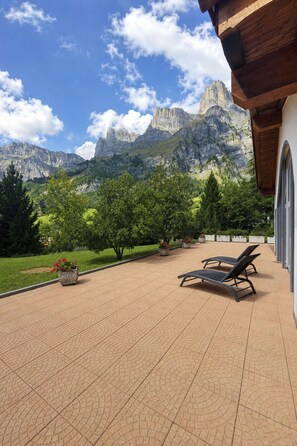 A patio with a view of mountains, outdoor seating, and potted plants. - Ambassador B22 # 2-bed apartment, Dusche, WC 2-Bettwohnung, Dusche, WC by Interhome (Leukerbad)