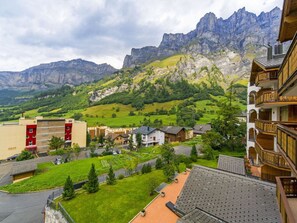 Ein Wohngebiet mit Bergblick, ein rotes Gebäude und ein Holzhaus mit Balkon.