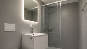 A modern bathroom with a glass-enclosed shower, a white sink, and a toilet. - Residenz Belair Leukerbad # 2-bed apartment, Dusche, WC by Interhome (Leukerbad)