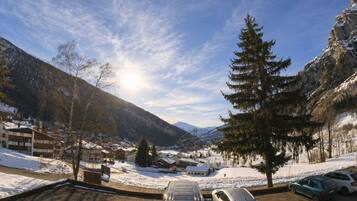 Ein Parkplatz mit Autos, Bergen im Hintergrund und blauem Himmel.
