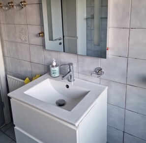 Chuveiro, secador de cabelo, toalhas de banho, sabonete