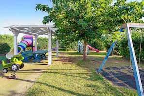A playground with a slide, swings, and a climbing structure.