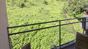 Un balcón con vistas a una ladera verde y exuberante.