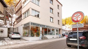 Un edificio de varios pisos con una tienda de alquiler de esquíes en la planta baja.