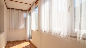 A room with wooden flooring, white walls, and large windows with sheer curtains. - Schwarzsee 2 by Arosa Holiday Appartement/Fewo Schwarzsee 2 by Interhome (Arosa)