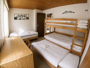 A room with bunk beds, a wooden desk, and a door leading to another room. - Residenz Clabina Leukerbad # 6-bed apartment, Bad, WC by Interhome (Leukerbad)