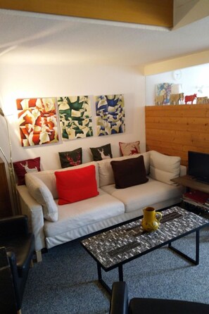 A living room with a sofa, a coffee table, and wall art. - Fortuna 317 # 6-bed apartment, Dusche, WC 6-Bettwohnung, Dusche, WC by Interhome (Leukerbad)