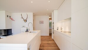 Une cuisine moderne dotée d’un îlot central, de planchers en bois et d’œuvres d’art décoratives sur les murs.