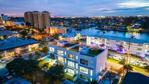 Ein modernes Hotel mit mehreren Etagen, einem Dachpool und einer Marina im Hintergrund.