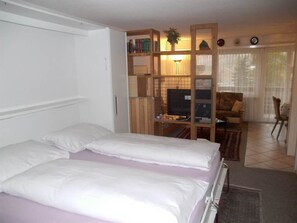 Ein Hotelzimmer mit Bett, Schreibtisch, Stuhl und Bücherregal.