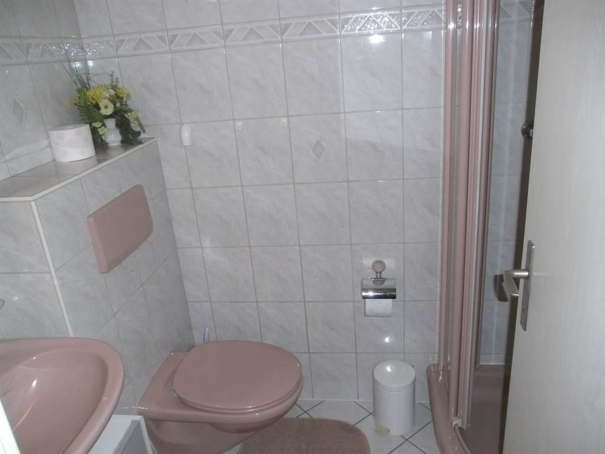 Une salle de bain comprenant des toilettes, un lavabo et un espace douche.