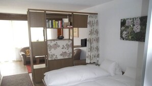 Un dormitorio con cama, armario, escritorio y silla.