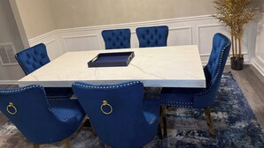 A conference table with a marble top surrounded by six blue upholstered chairs with gold accents. - Bleu et Doré (Atlanta)
