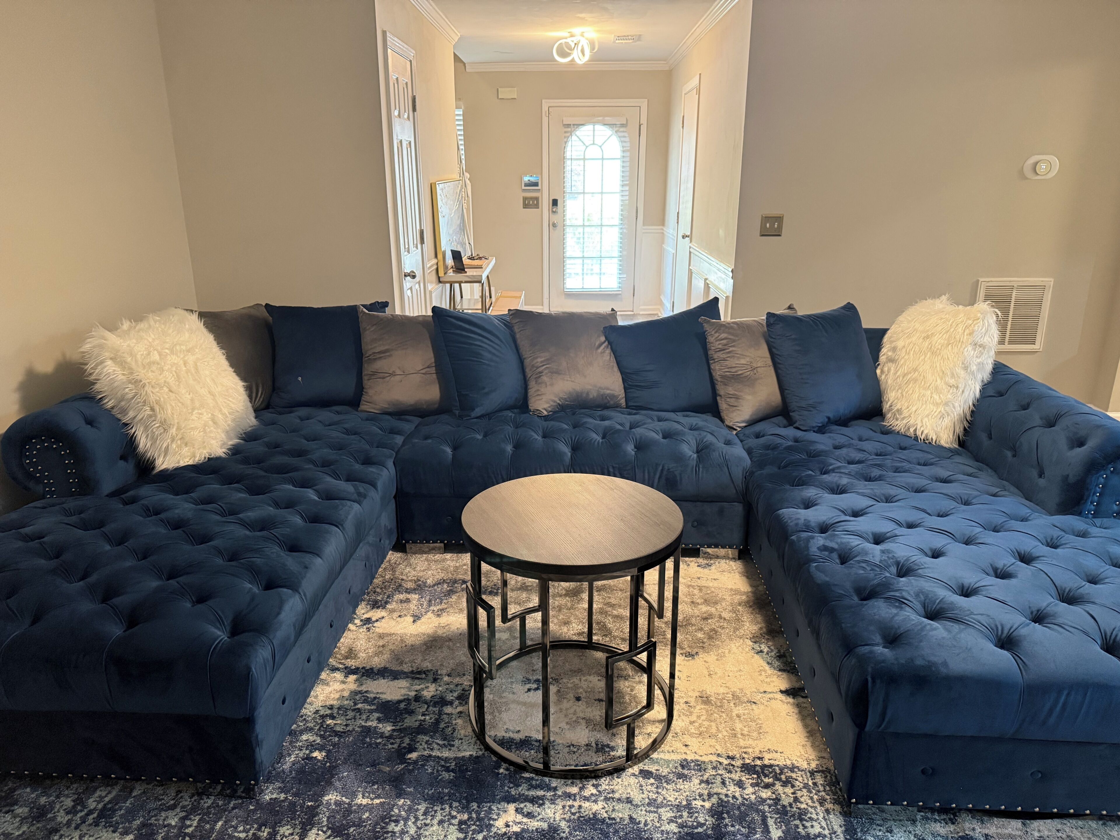 Sofá modular com mesa de centro redonda em um corredor.