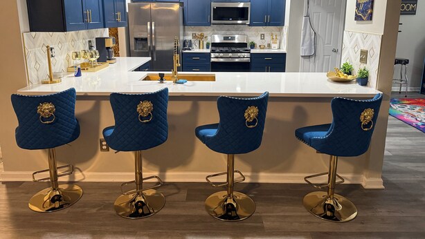 A modern kitchen with dark blue cabinets, stainless steel appliances, and a central island with bar stools. - Bleu et Doré (Atlanta)