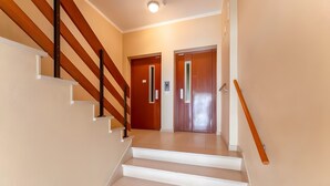 Eine Treppe mit hölzernen Geländern und weißen Stufen, die zu einer Tür mit einem Griff führt.