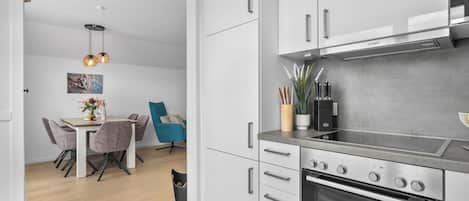 A modern kitchen with white cabinetry, a Bosch range hood, and a built-in oven.
