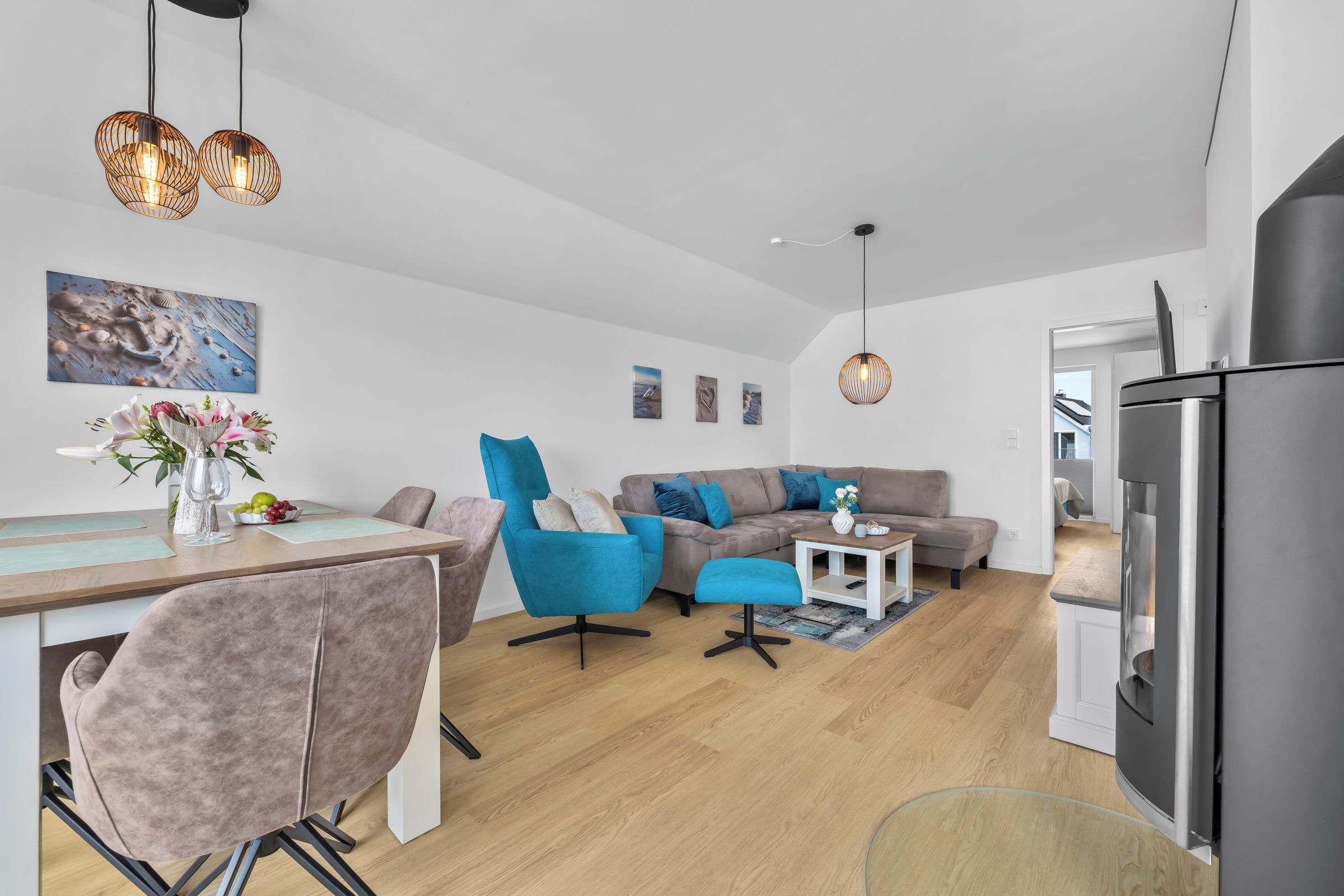 Een moderne woonkamer met een bank, stoelen, een eethoek en een keuken.