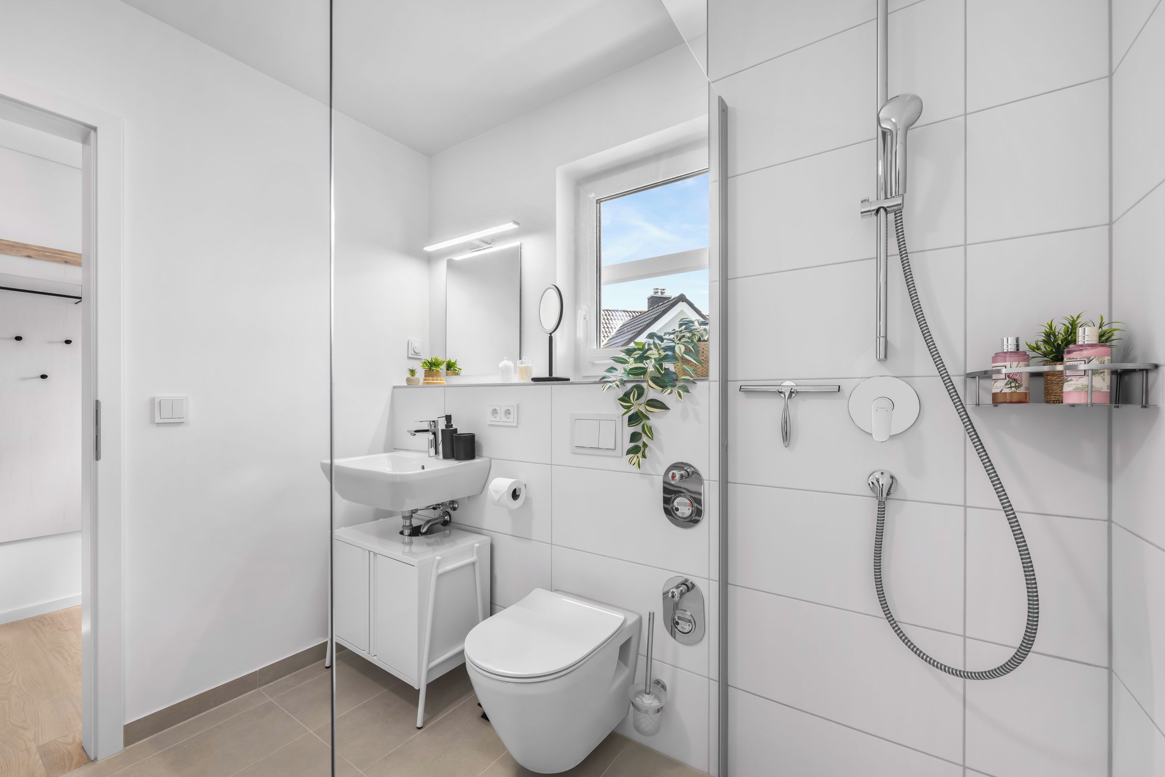 A modern bathroom with a toilet, sink, and shower.