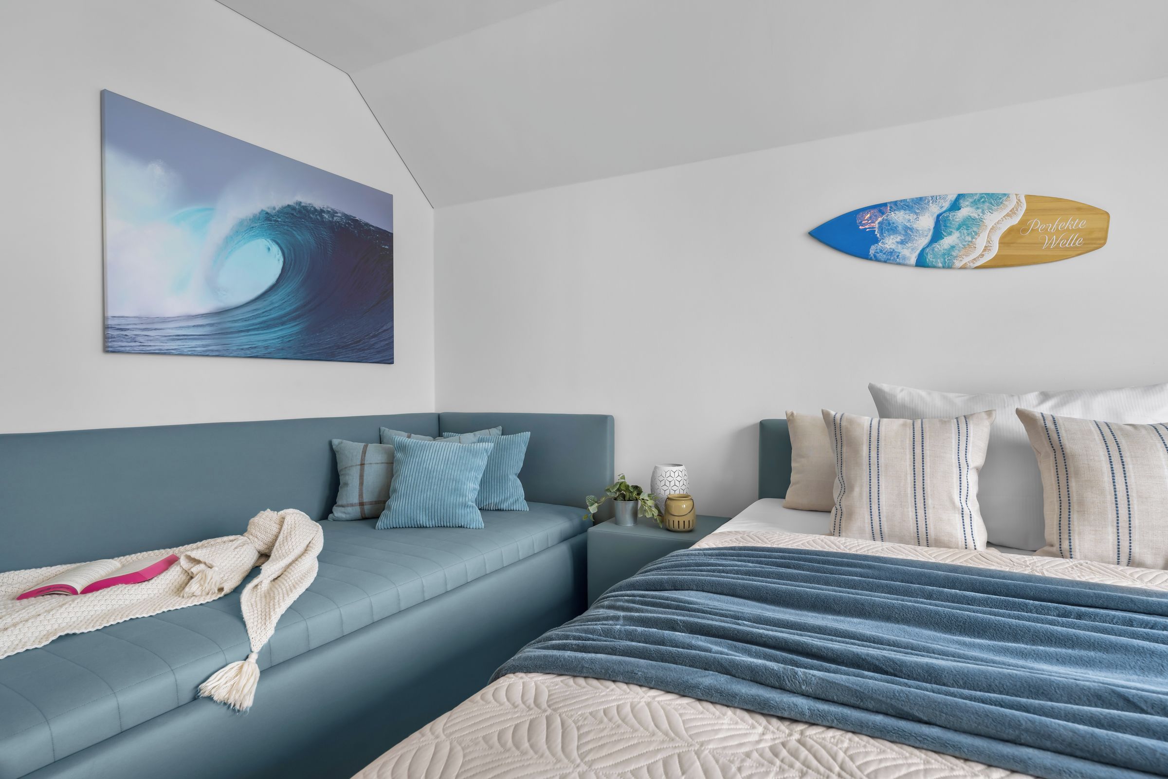 Una camera da letto con un letto, un divano e un'asse da surf fissata alla parete.