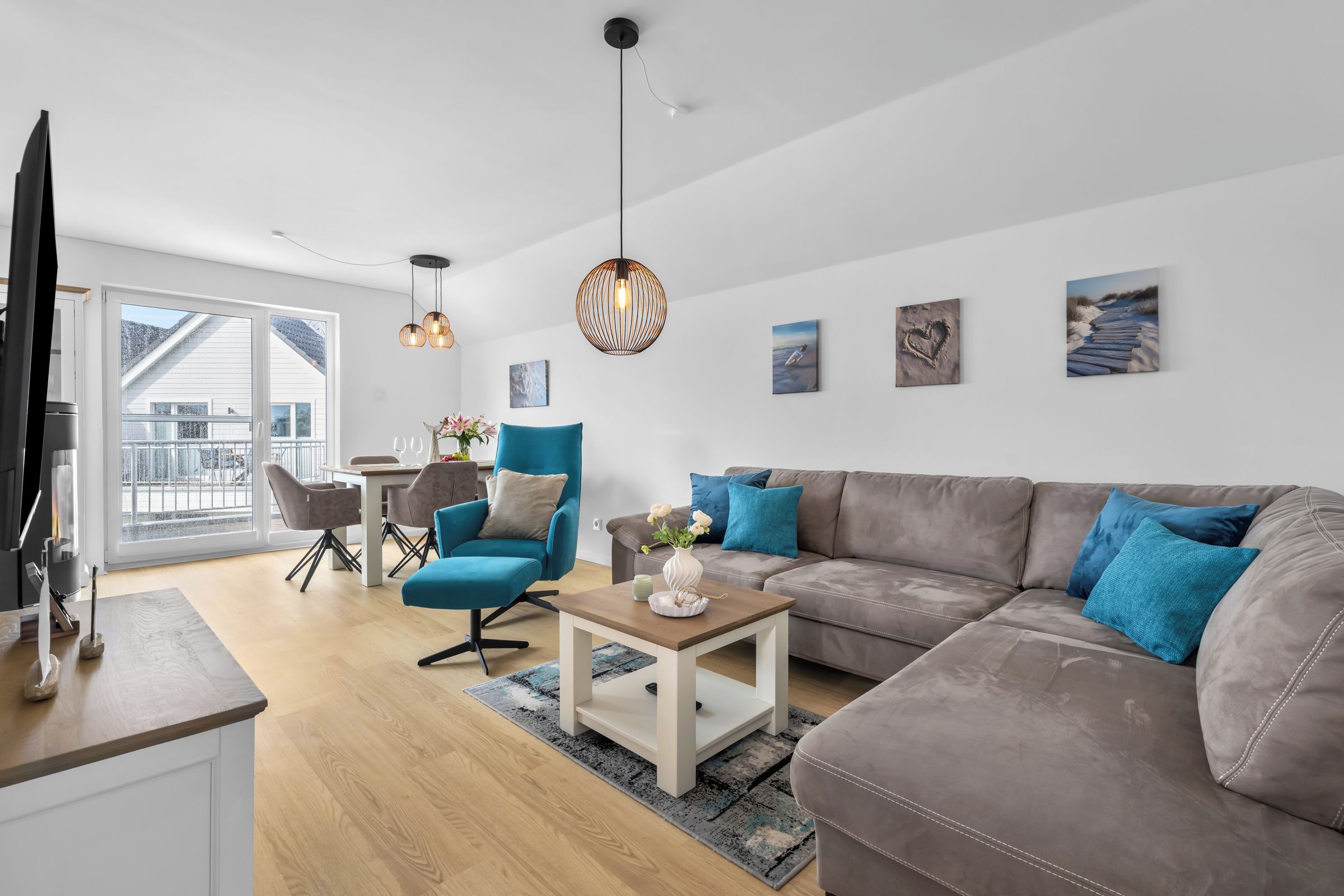 Una sala moderna con un sofá, sillones, una mesa de centro y un comedor con mesa y sillas.