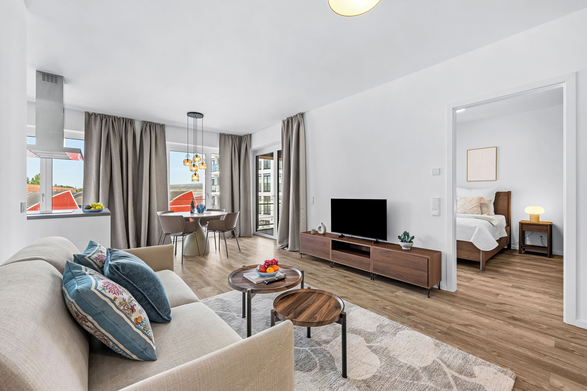 Un salon moderne comprenant un canapé, une table basse, un téléviseur et un coin repas.