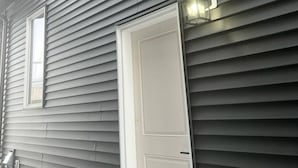 A building with horizontal siding, a white door, and a small window. - Room-magnificent Brand New Luxurious Bas (Edmonton)