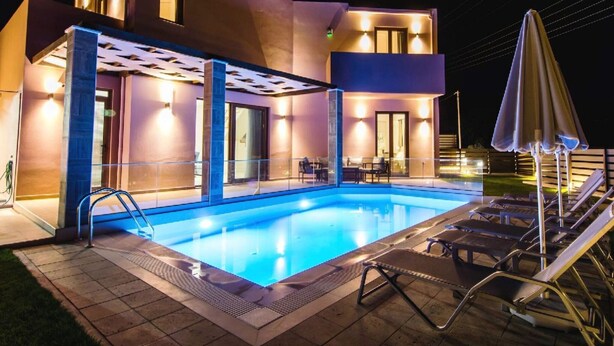 Una moderna casa a due piani con piscina, area salotto esterna e patio coperto.