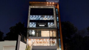 A modern townhouse with a prominent 'TOWNHOUSE' sign, a visible garage, and a staircase leading to the entrance. - Townhouse Rispana Pul Haridwar (Dehradun)
