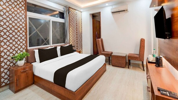 A modern bedroom with a bed, a desk, a chair, and a TV. - Townhouse Rispana Pul Haridwar (Dehradun)