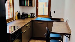 A compact kitchen with a built-in oven, a sink, and a window. - House with a renovated courtyard—"Le Cocon d'Albi"—5 minutes from downtown (Albi)