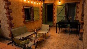 An outdoor patio with a sofa, chairs, a table, and a potted plant. - House with a renovated courtyard—"Le Cocon d'Albi"—5 minutes from downtown (Albi)