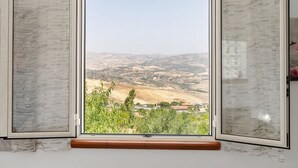 A window with a view of a hilly landscape, a wooden window frame, and a curtain. - NEW LIFE Villalba Resort - Room '101' with Shared Terrace, Wi-Fi and Air Conditioning (Villalba)