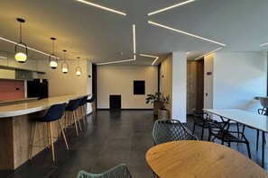 A modern kitchen with a bar area, seating arrangements, and a potted plant. - Loft with a private garden and coworking space near Corferias and the U.S. Embassy (Bogotá)