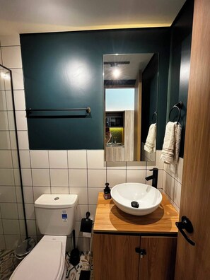 Un bagno moderno con il water, un lavandino e uno specchio.