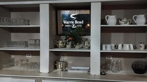 Una exhibición de cristalería y utensilios de cocina en estantes.
