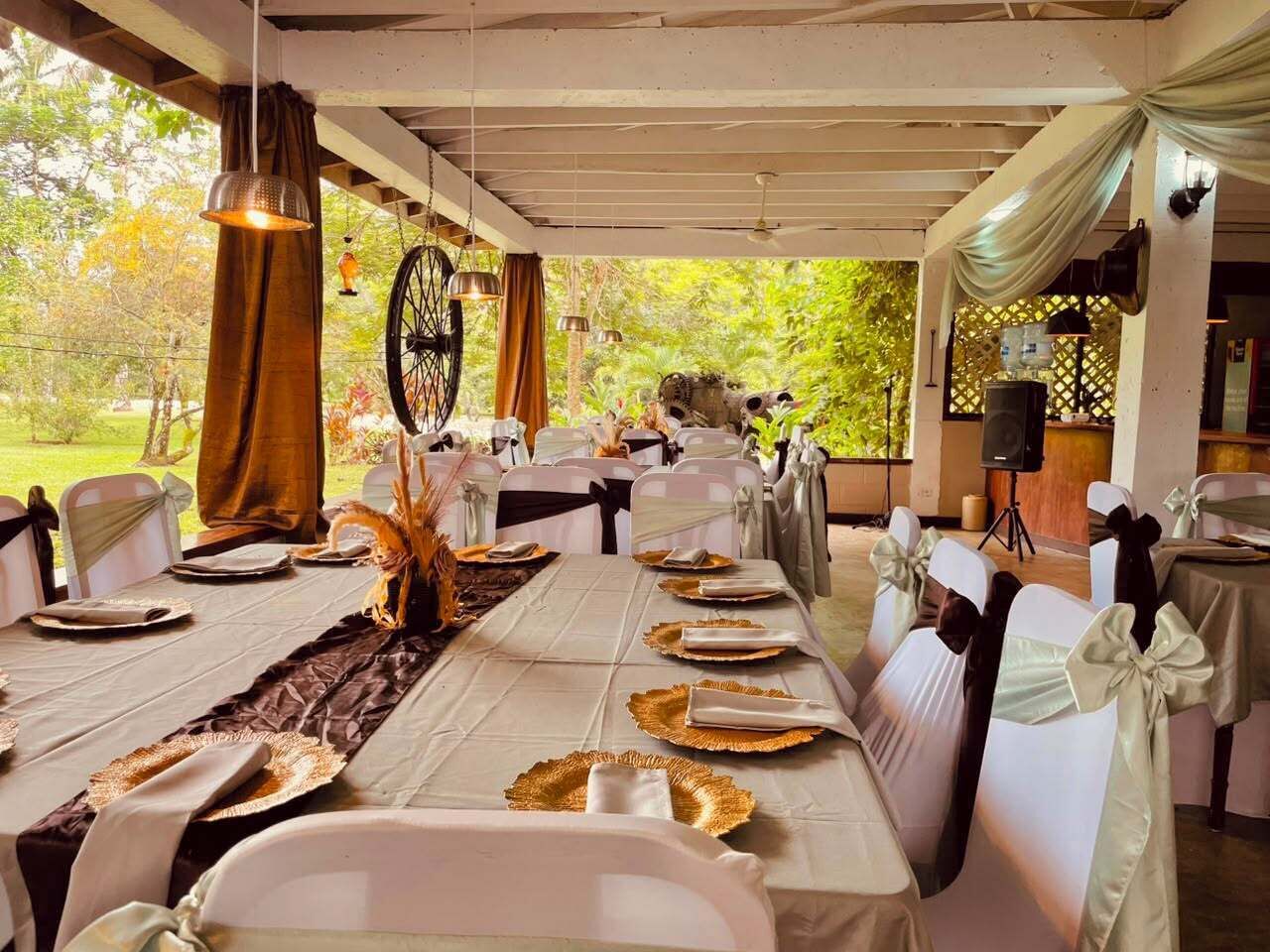 Una larga mesa de comedor con sillas blancas, lista para una comida.