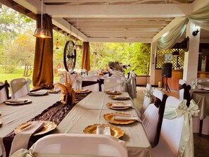 Una larga mesa de comedor con sillas blancas, lista para una comida.