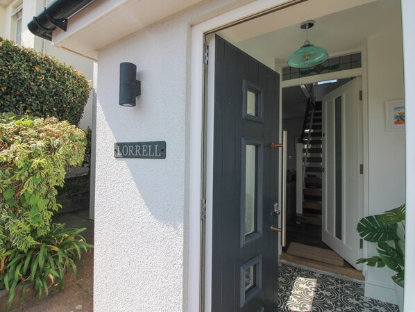 A door labeled 'LORRELL' with a black door and a white wall. - Lorrell (Salcombe)