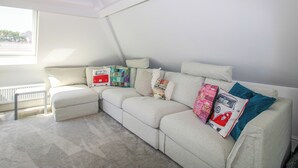 Ein modernes Wohnzimmer mit einer Eckcouch, einer Heizung und einem Fenster mit Blick.