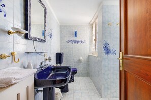Un bagno con due lavandini, uno specchio, un portasciuga asciugamani e una doccia.